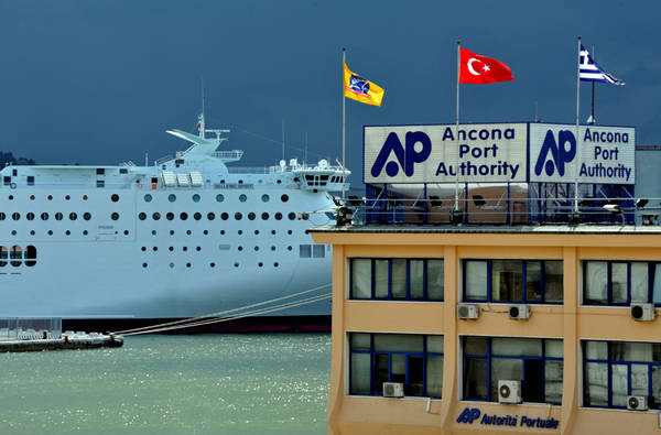 (ANSA) - ANCONA, 7 MAG - Bandiere dell'Autorita' portuale al vento prima del temporale e nave bianca sullo sfondo.